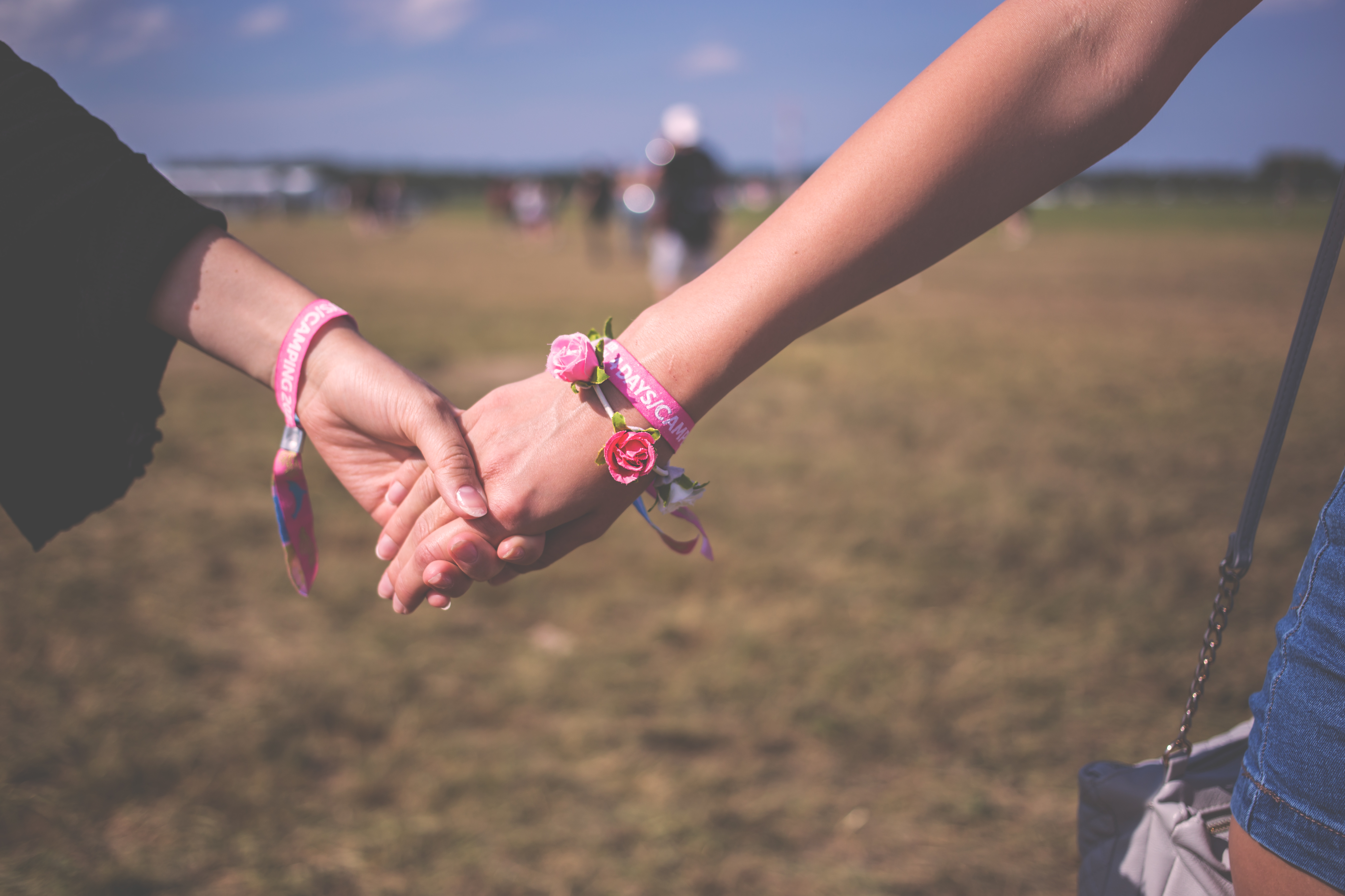 red and pink floral bracelet holding hands